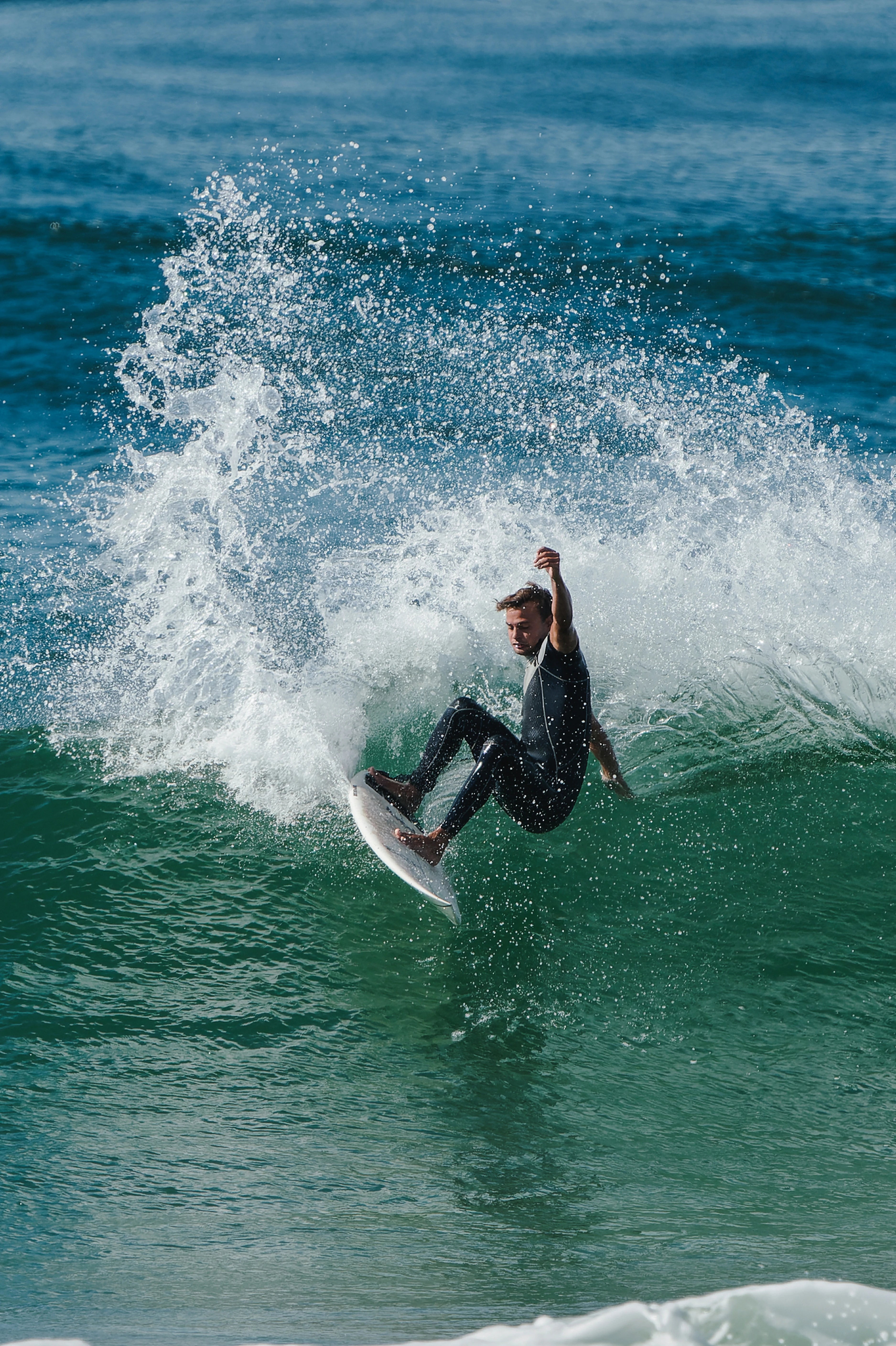 Surfer in a wetsuit riding a wave with water splashing around