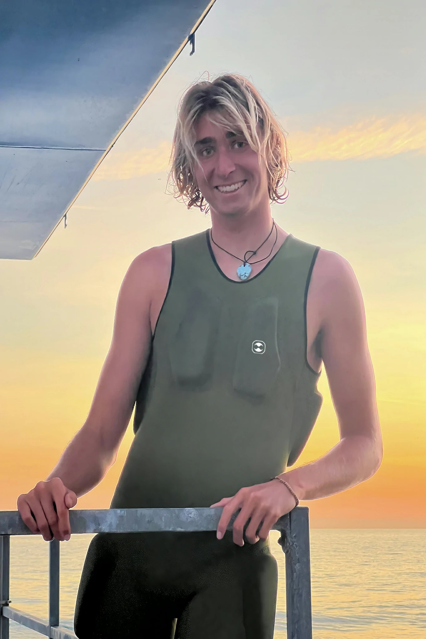 Person wearing a green sleeveless Hydro Guard Impact Short John with a sunset in the background