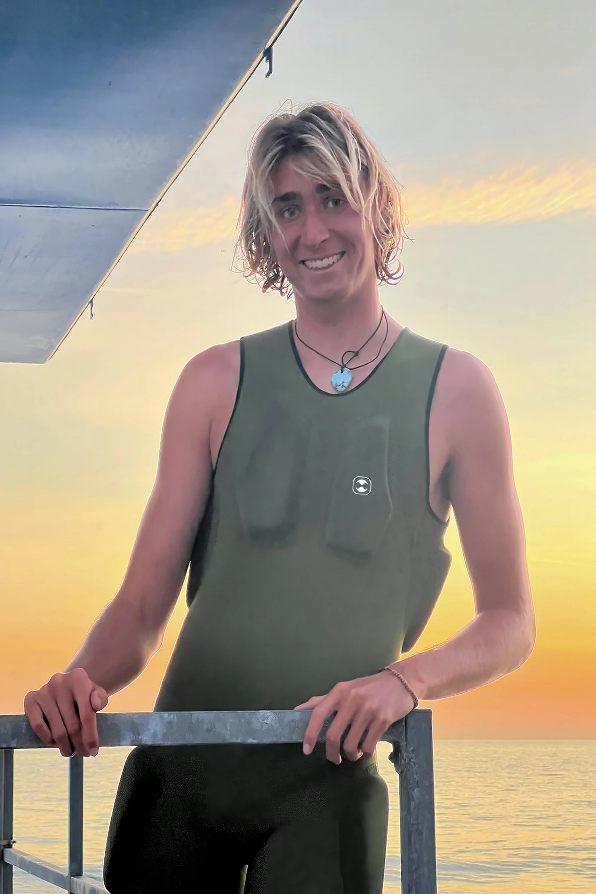 Person wearing a green sleeveless Hydro Guard Impact Short John with a sunset in the background