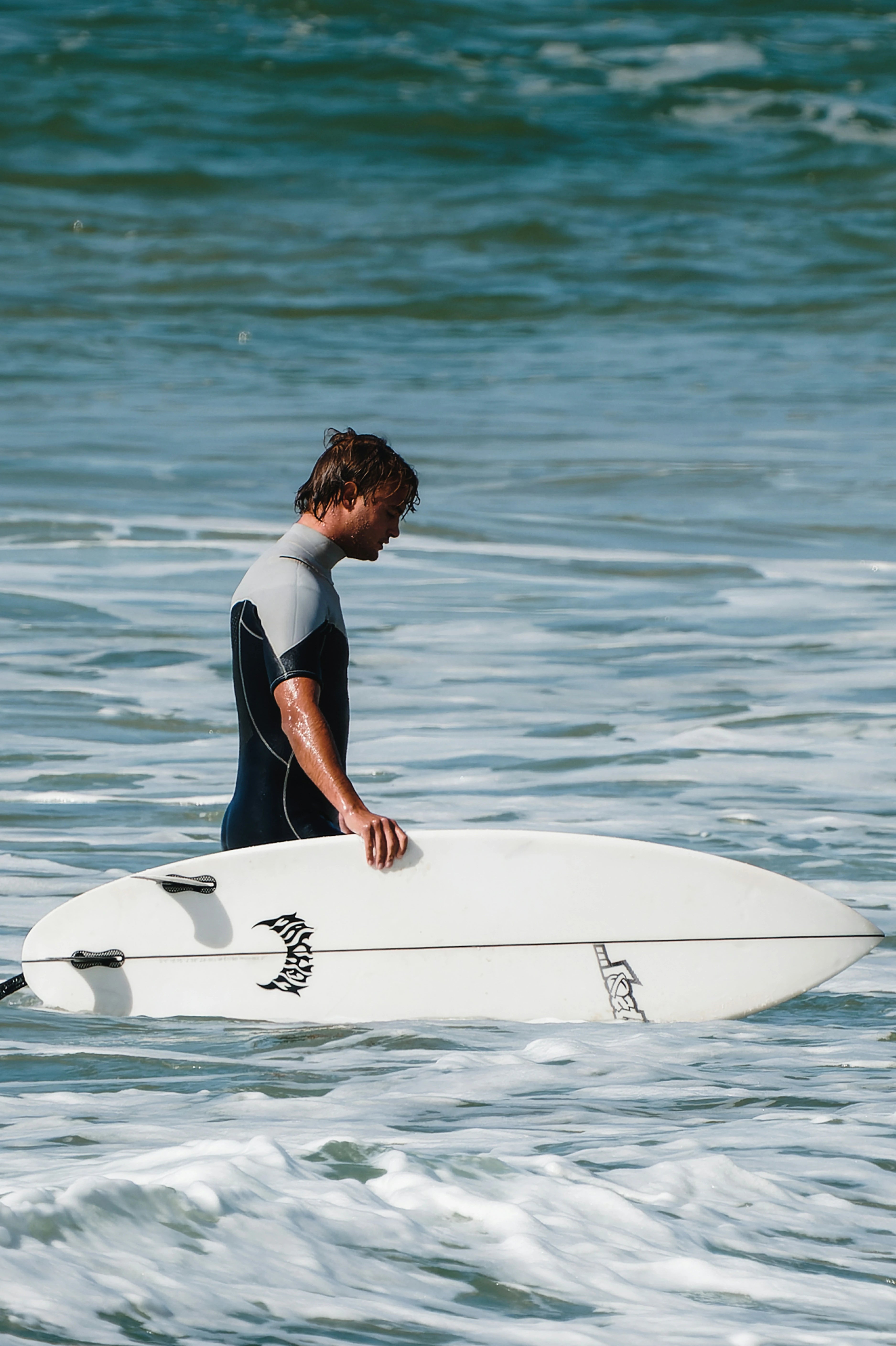 Person holding a surfboard in the ocean