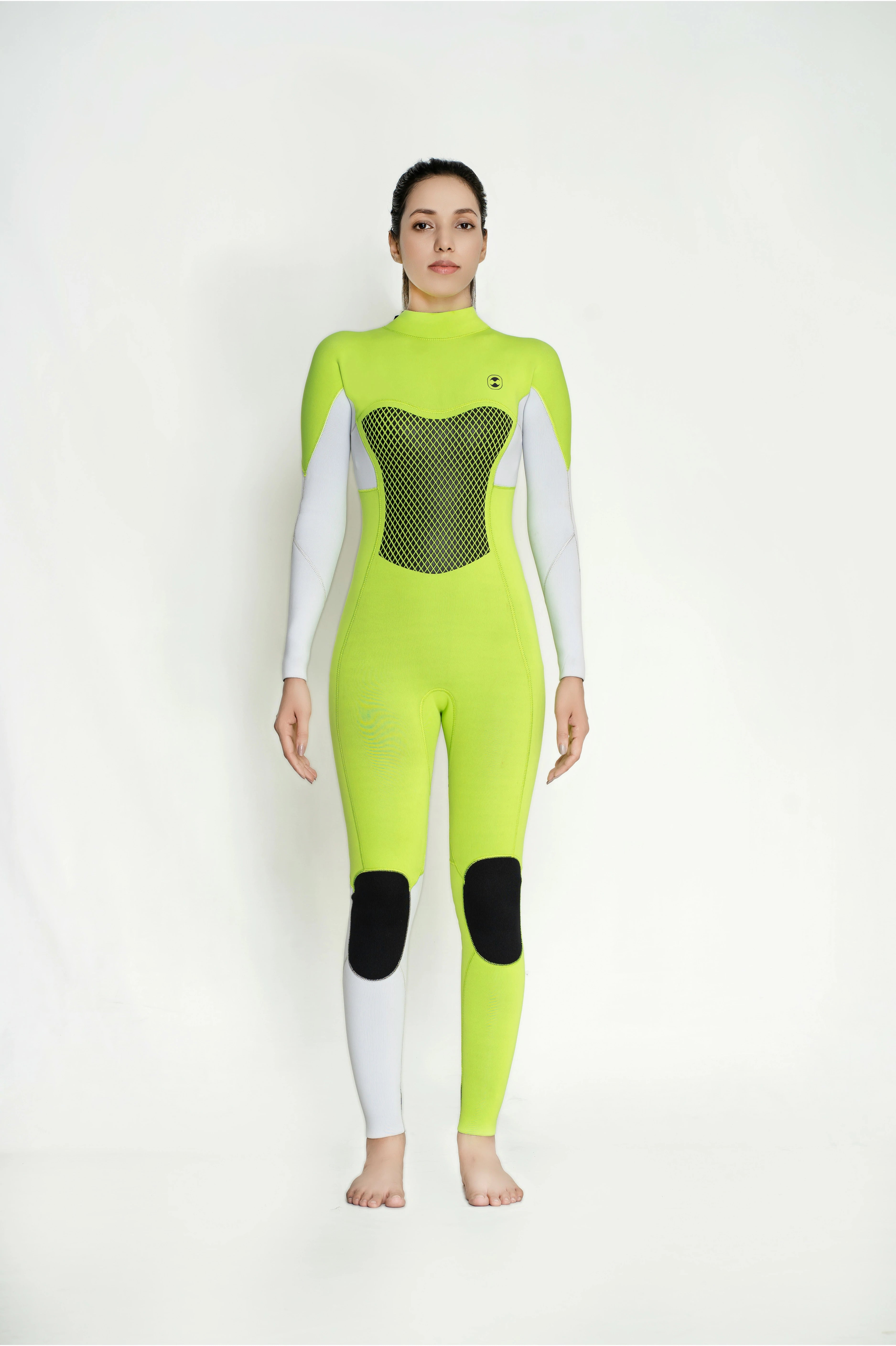 A model wearing a full-body neon yellow-green classic back zip wetsuit with white sleeves and lower legs, a black mesh chest panel, and black knee patches, standing against a plain white studio background.