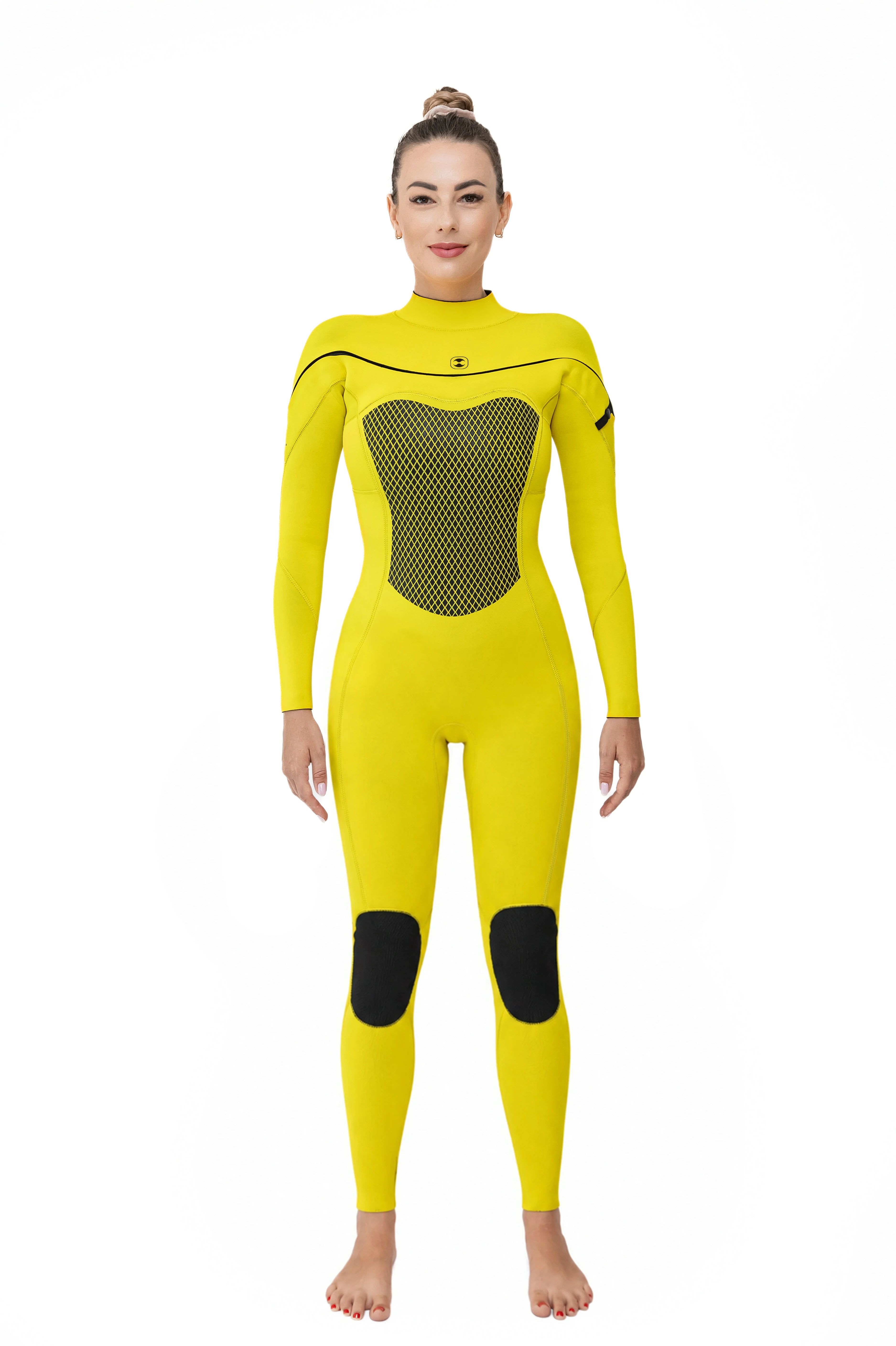 A woman modeling a bright yellow full-body long chest zip wetsuit with black mesh paneling on the chest and black knee patches, standing against a plain white background.